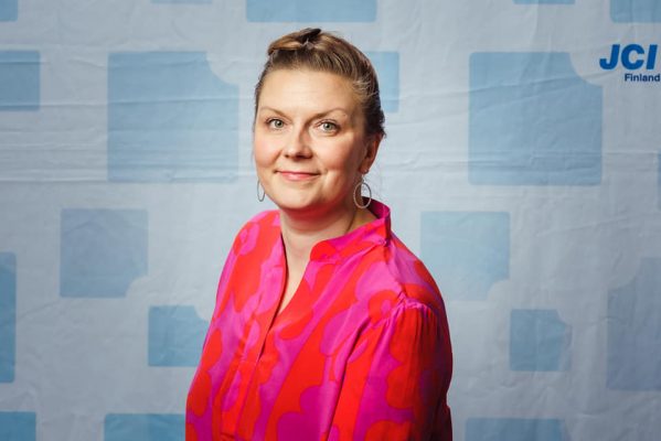 Nainen hymyilee kameralle